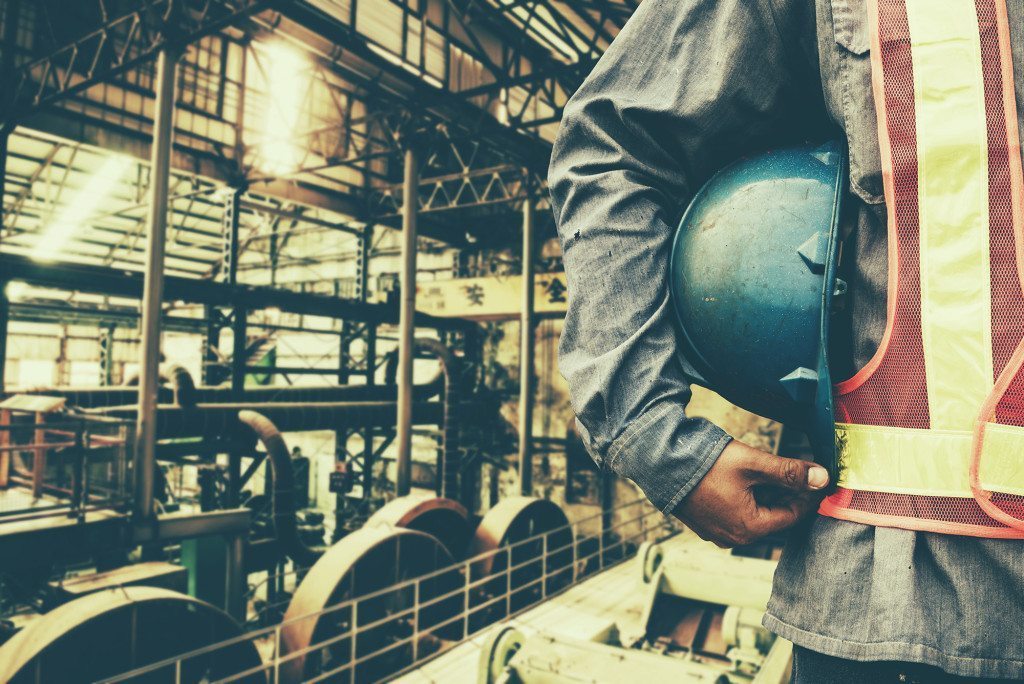 construction worker checking location site with crane on the background